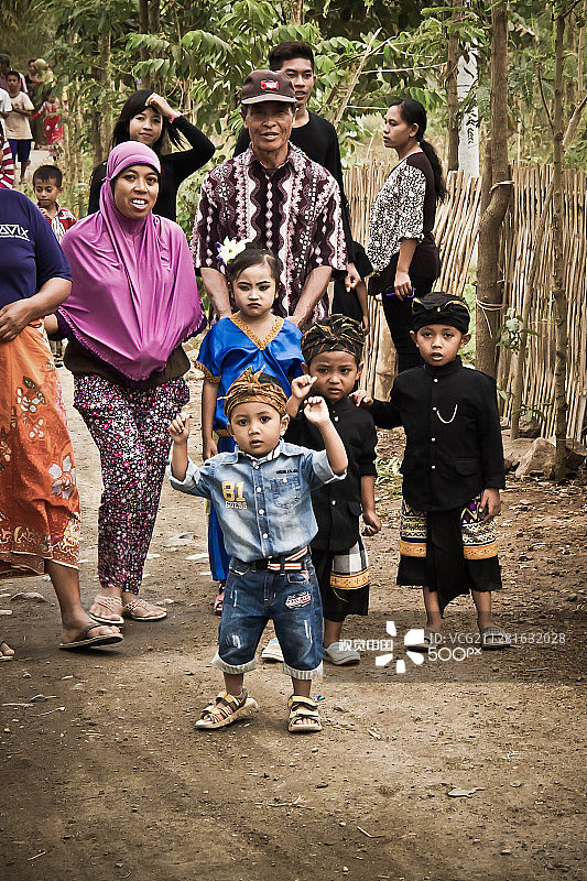 在印度尼西亚龙目岛，一家人试图让宝宝在照片中行走图片素材