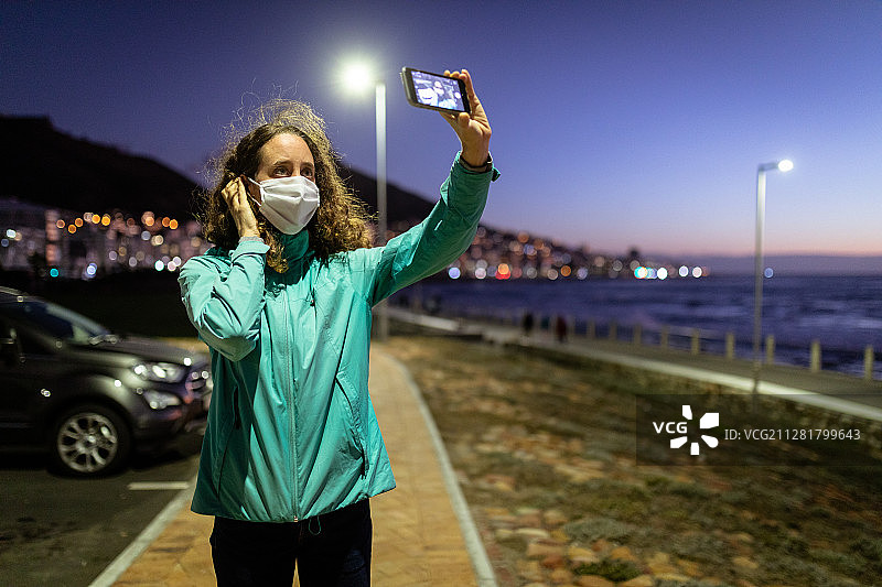 戴防护口罩在街上拍照的白人女性图片素材
