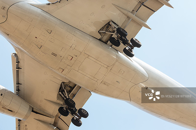 放下起落架超低空飞行准备降落的民航客机机腹局部特写图片素材