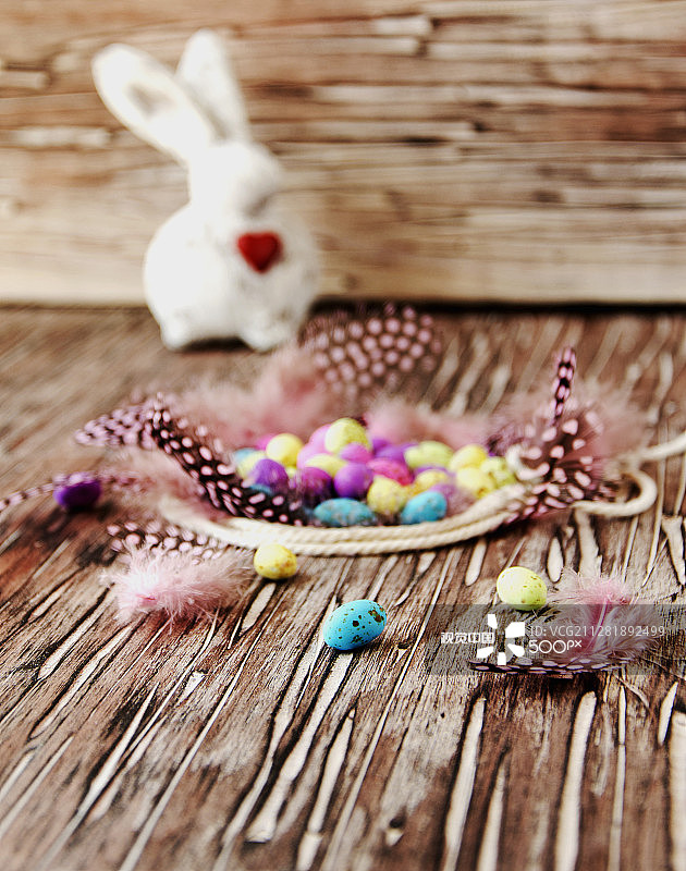 复活节彩色彩蛋、羽毛、蓝色木板图片素材