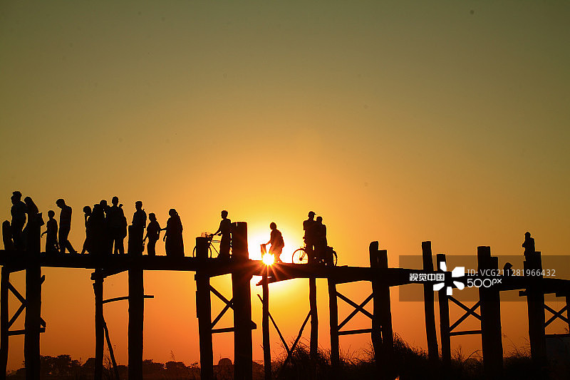 阿玛拉布拉乌本桥日落时分，人们横跨伊洛瓦底江图片素材