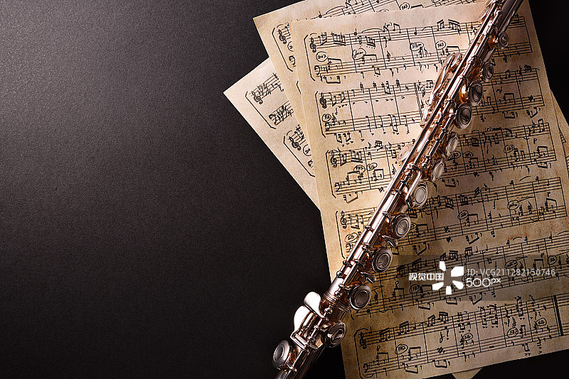 黑桌上的横笛和旧乐谱顶视图图片素材