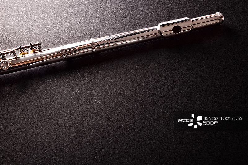 黑色桌面上横向长笛的顶部和吹口图片素材
