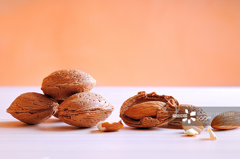 白色桌子与橙色背景上的杏仁图片素材
