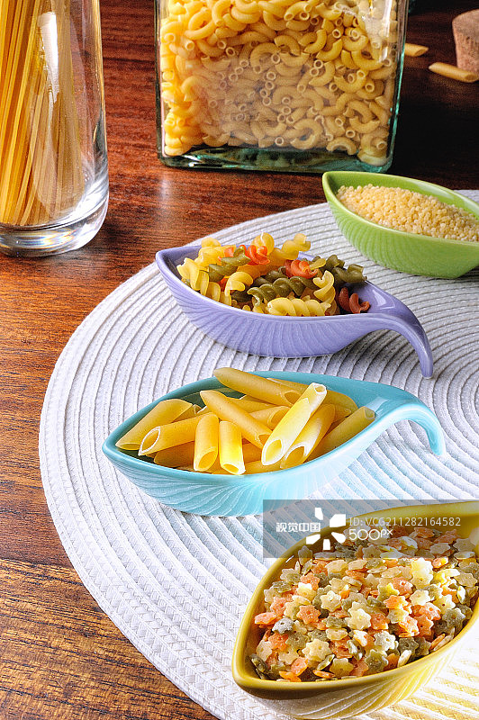 白色桌布上的陶瓷容器中盛放的未煮意大利面图片素材