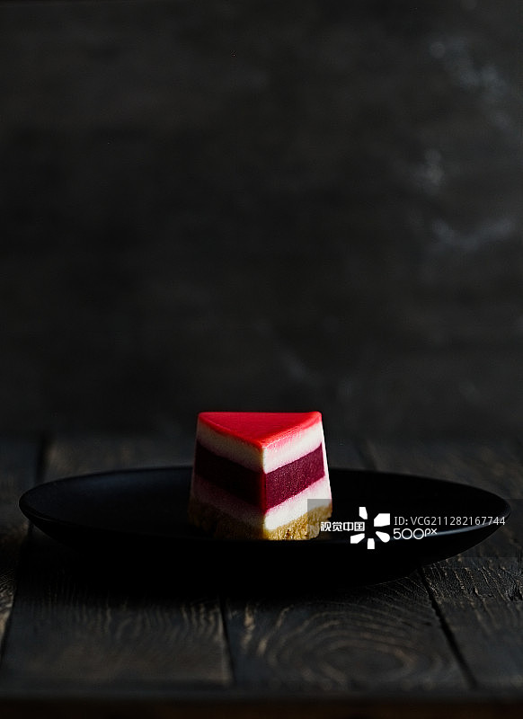 深色背景下的草莓芝士蛋糕图片素材