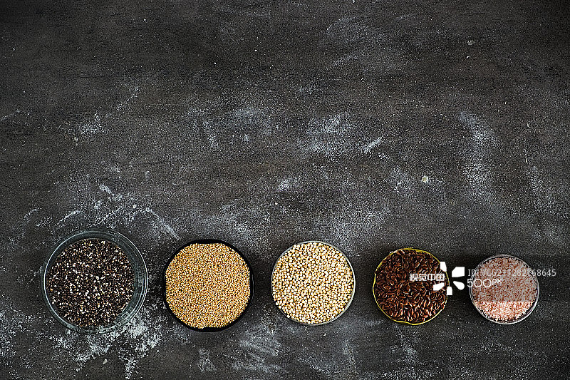 深灰色背景上的各种超级食品：奇亚籽和苋菜图片素材