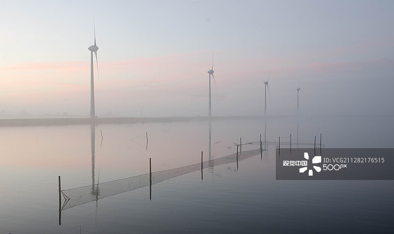 恩克赫伊曾莱利斯塔德堤坝附近的日出风车图片素材