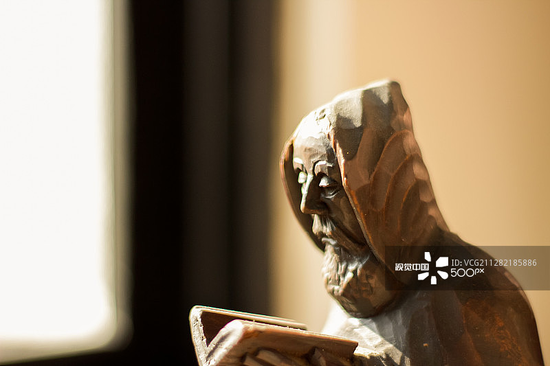 阅读圣经的木制僧侣雕像图片素材