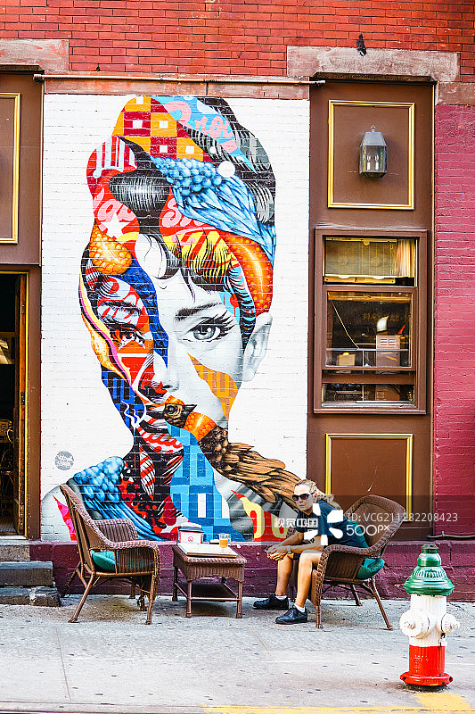 有人坐在色彩鲜艳的涂鸦附近图片素材