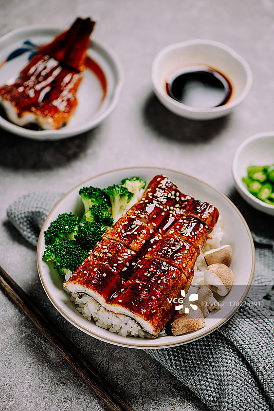 灰色桌面上放着日式鳗鱼饭图片素材