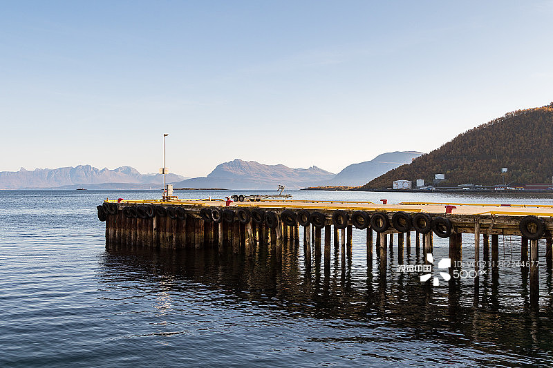 挪威哈尔斯塔，码头上排列着轮胎，背景是海洋和山脉图片素材