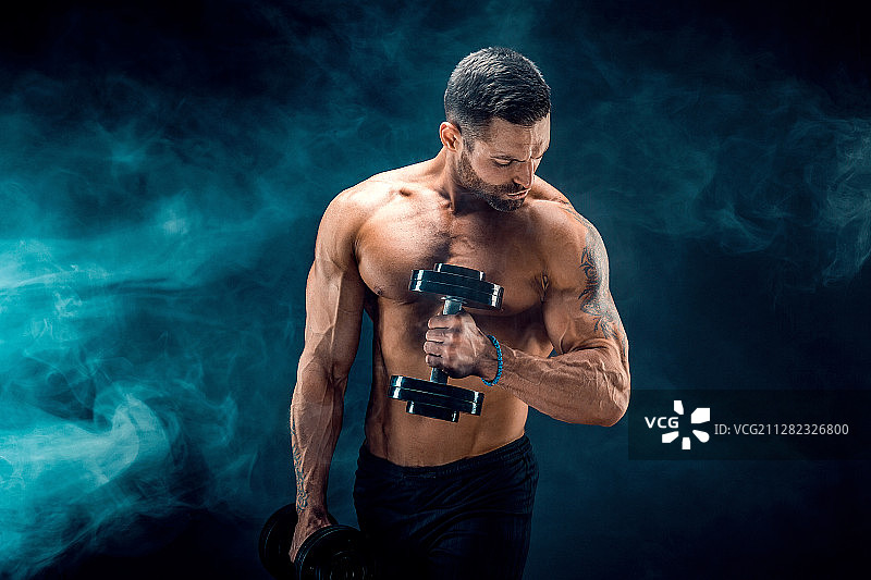 腹肌完美、肩部、肱二头肌、肱三头肌和胸部健壮的年轻男子图片素材