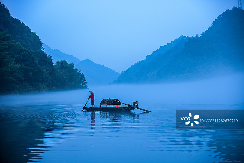 大山里江面雾气弥漫中的小船和人影图片素材