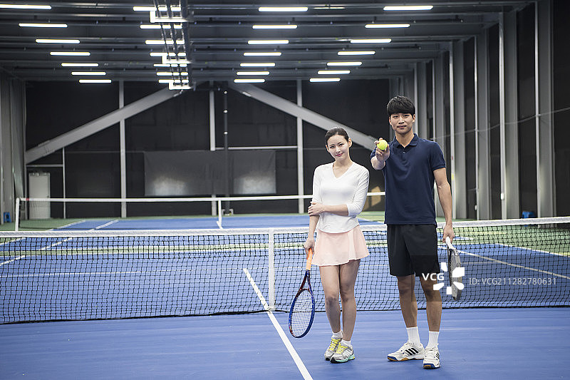 网球场情侣手持网球拍摆姿势图片素材