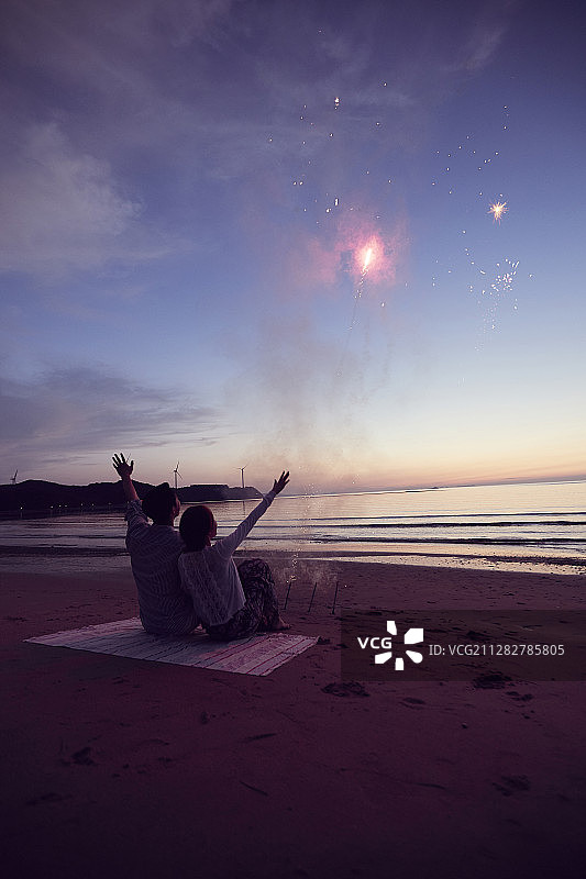 情侣坐在海滩上看星星照片图片素材
