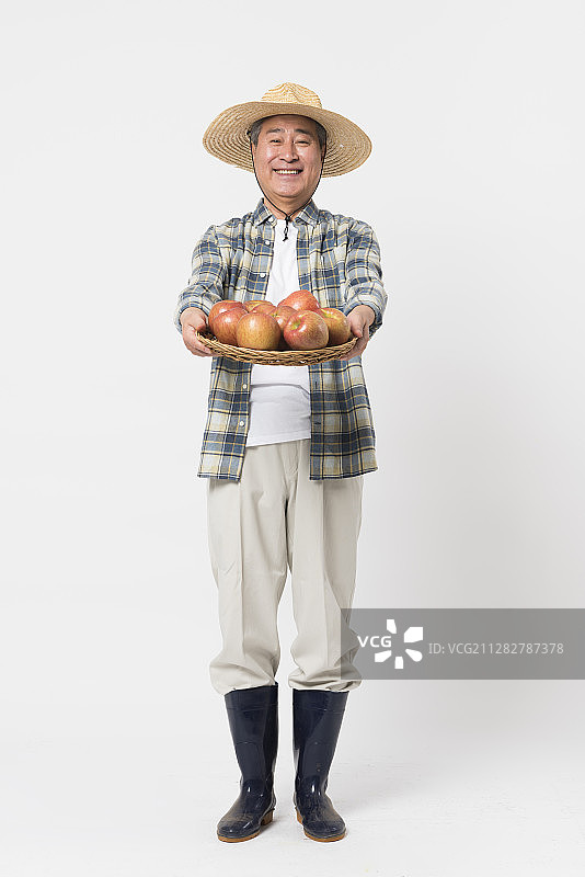 农民拿着一篮苹果的摄影图片素材