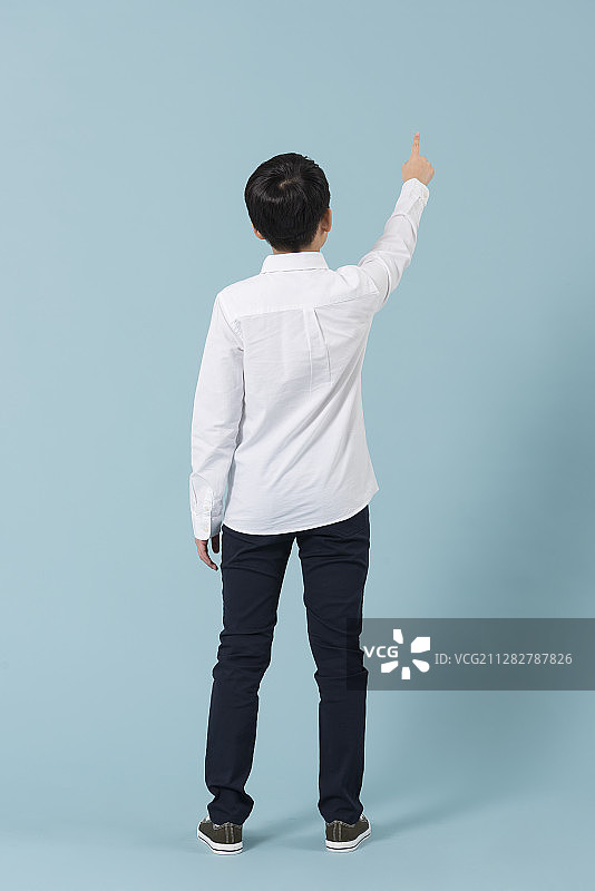 站立着向上指的青少年男孩摄影图片素材