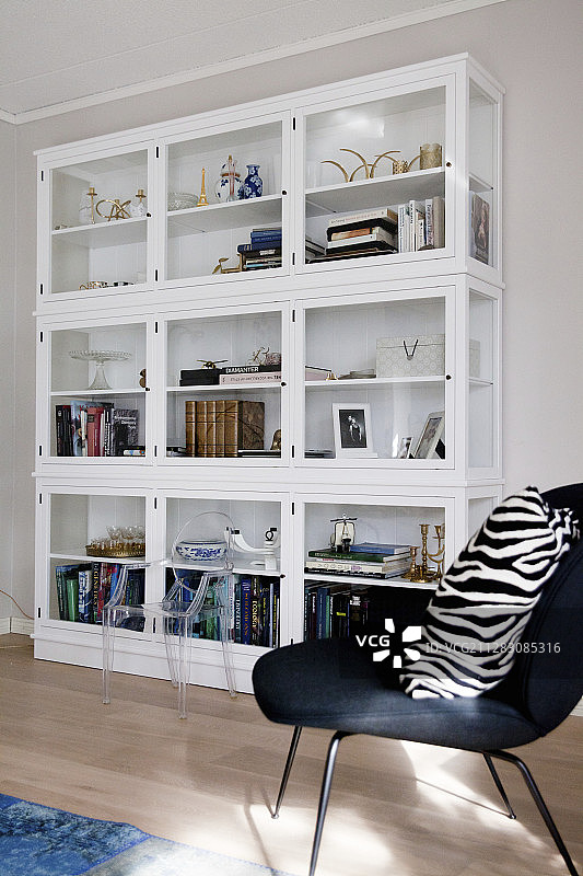 玻璃柜前的斑马纹靠垫黑色扶手椅图片素材