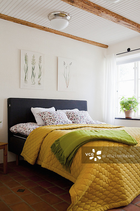 乡村卧室床上黄色绗缝床罩图片素材