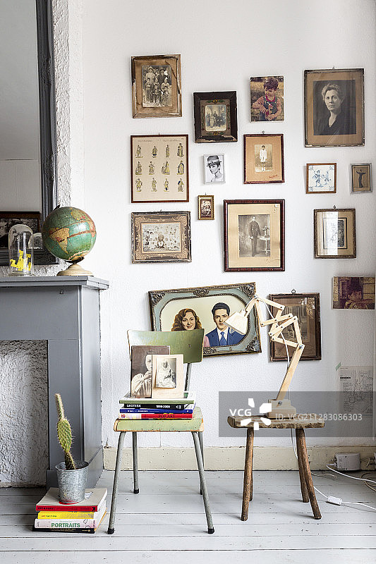 老椅子和凳子上方的墙上的复古棕褐色照片图片素材