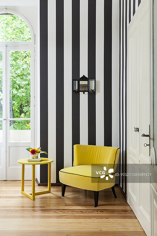 黄色丝绒扶手椅和边桌，搭配黑白条纹墙图片素材