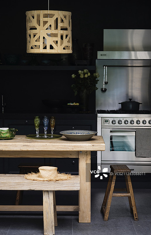 黑色厨房中的复古木桌、凳子和长椅图片素材