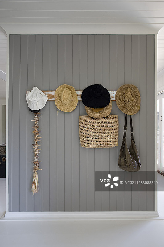 灰色板墙上衣帽架上的夏帽和包图片素材