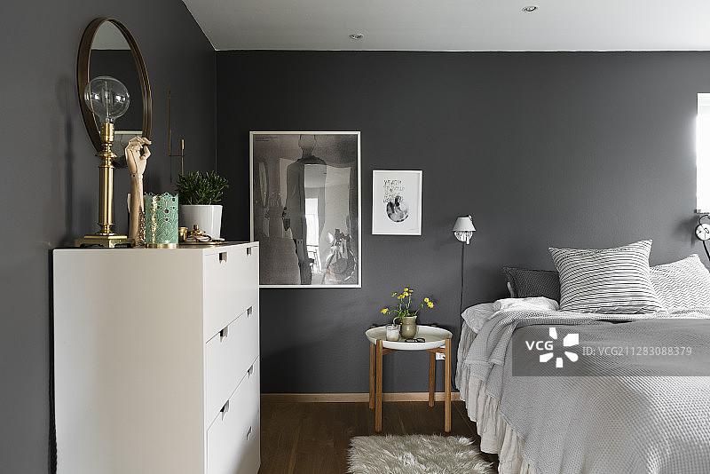 卧室：双人床和白色抽屉柜，深灰色墙壁图片素材