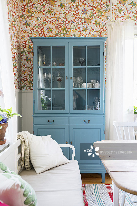 餐厅里带有花卉壁纸的蓝色梳妆台图片素材