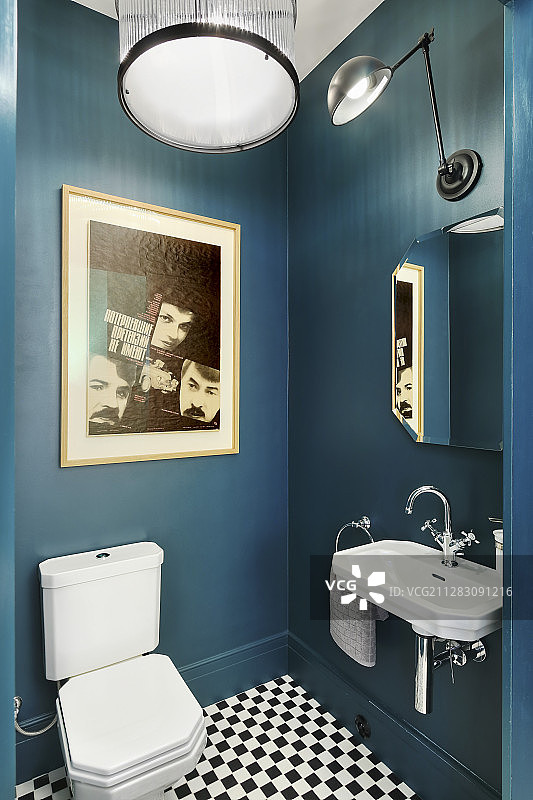 带深蓝色墙壁的浴室中的水槽和马桶图片素材