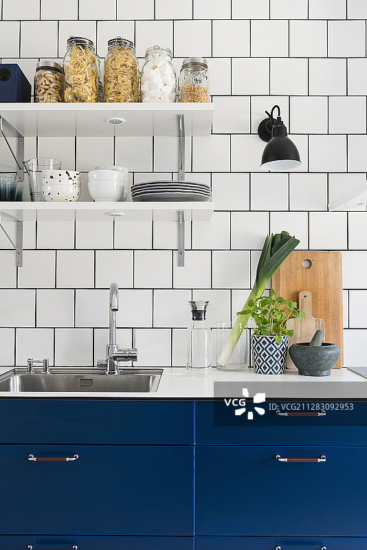 带蓝色橱柜和白色瓷砖墙的厨房图片素材