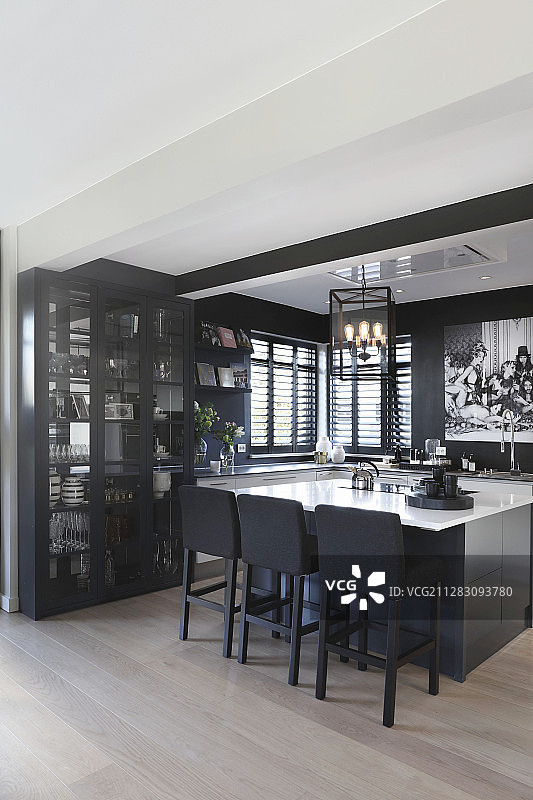 开放式厨房中的展示柜、岛台和黑色墙壁图片素材