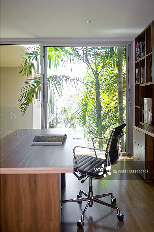 书房里的书桌和转椅，配有玻璃推拉墙图片素材