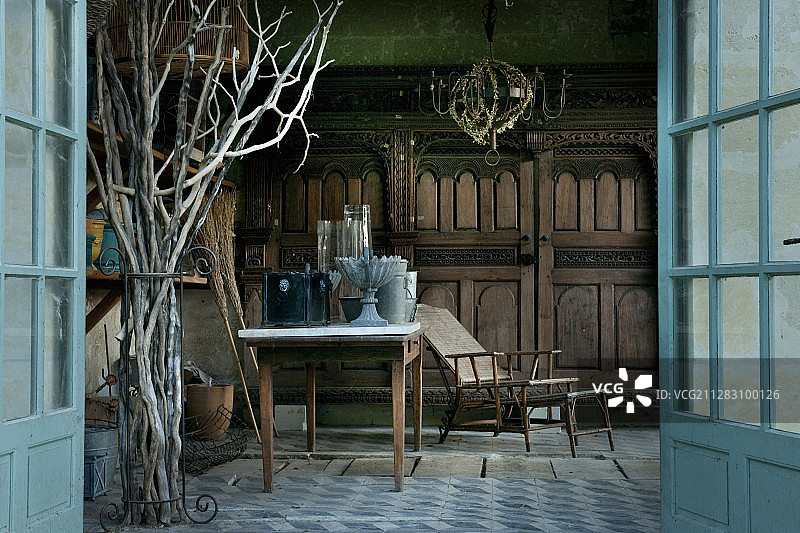 透过敞开的双扇门看带有古董园艺设备的避暑小屋图片素材