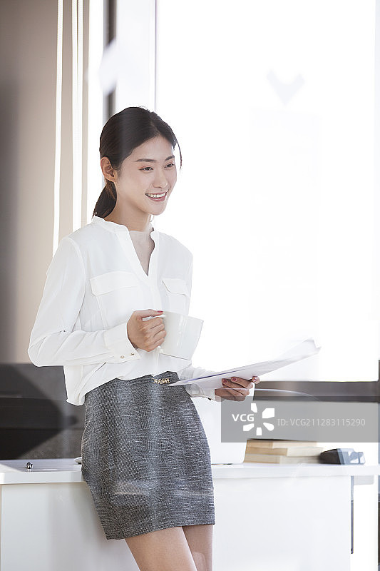 年轻商务女士在办公室看文件图片素材
