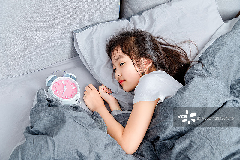 躺在床上睡觉的亚洲小女孩图片素材