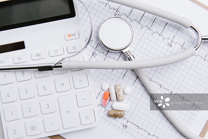 心电图上放着听诊器和计算器药物和笔图片素材