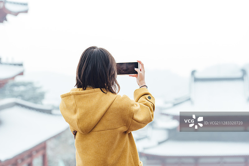下雪天气站在中国古建筑前面的亚洲女人图片素材