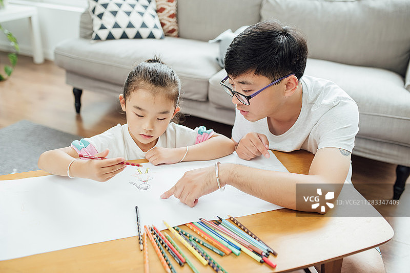 一对年轻的亚洲夫妻正在和孩子一起画画图片素材