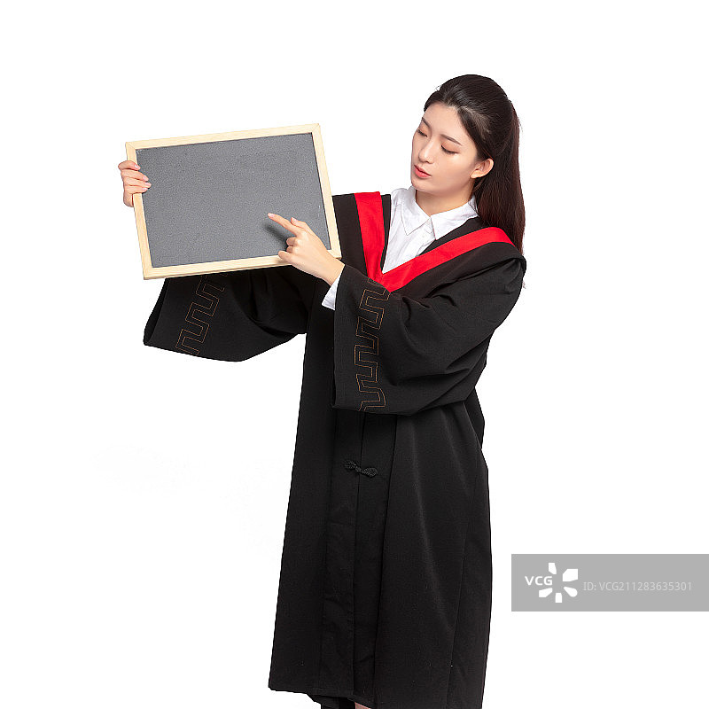 白色背景里，身穿学术服手拿小黑板的美丽东方女孩图片素材