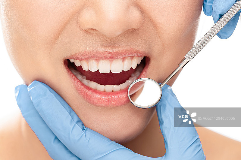 牙医给青年女人检查牙齿图片素材