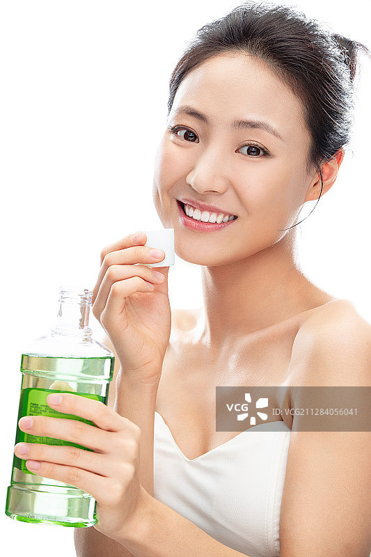 拿着漱口水漱口的青年女人图片素材