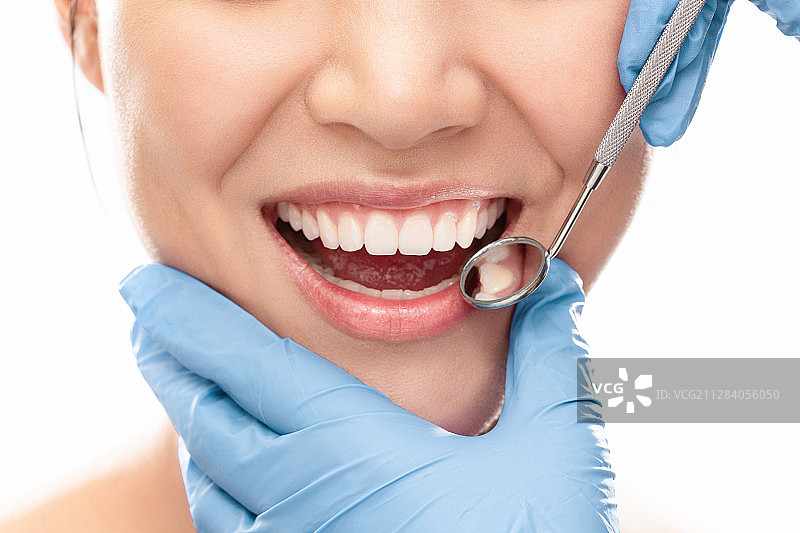 牙医给青年女人检查牙齿图片素材