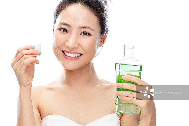 拿着漱口水漱口的青年女人图片素材