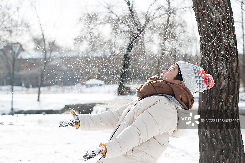 快乐的小男孩在雪地里玩耍图片素材