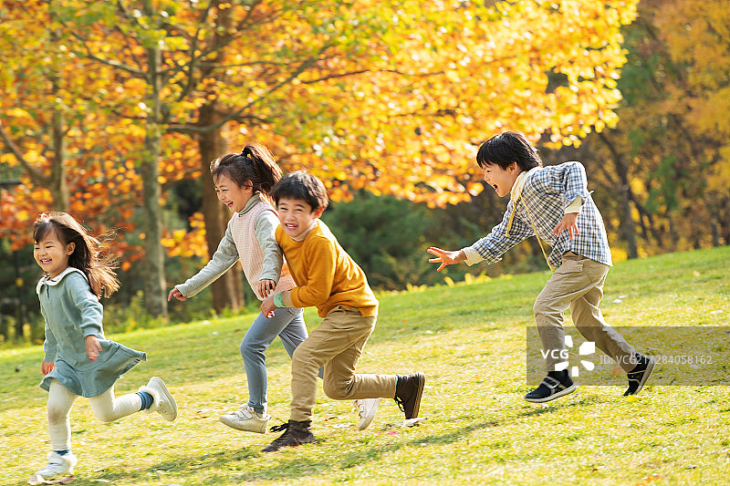 小朋友们在公园里快乐奔跑图片素材