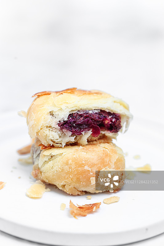 放在白色盘子上的玫瑰鲜花饼图片素材