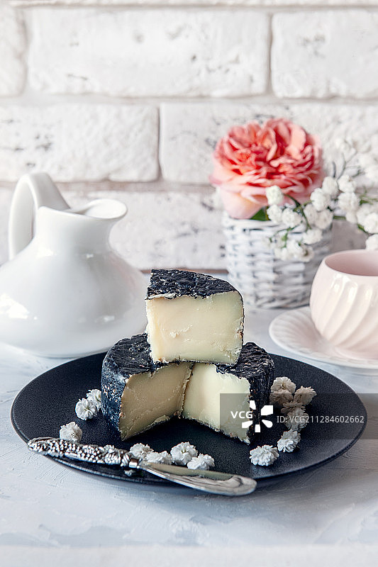 蓝色图尔高硬奶酪，配茶壶、咖啡杯和植物图片素材