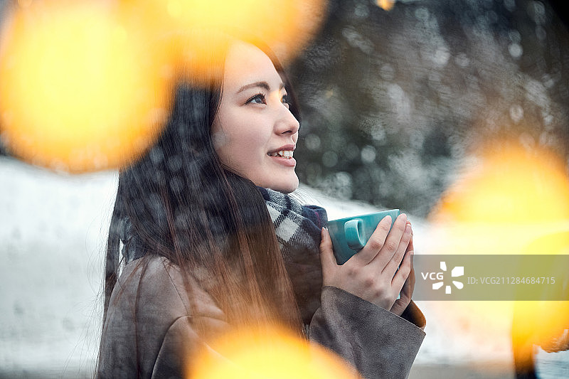 女子在雪中享受茶歇时光图片素材
